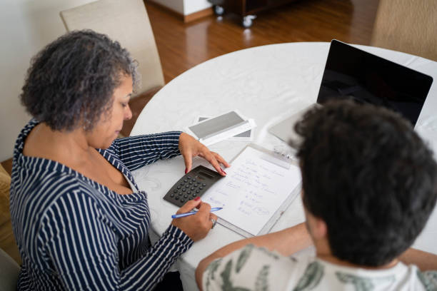 Mother and son planning their finances at home stock photo