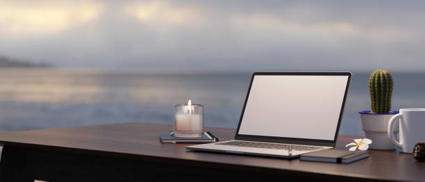 istock Modern workspace with laptop mockup on table against blurred sea and sky view 1393912443