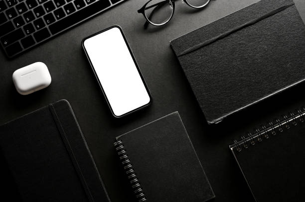 istock Modern black office workspace background with office accessories and devices mockup. 1393912470