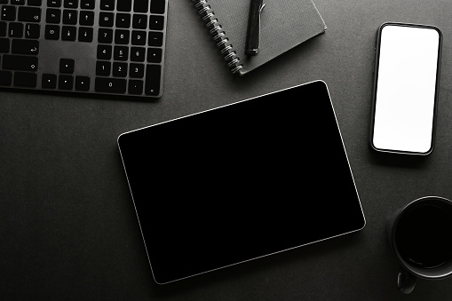 Minimal black office workspace background with smartphone mockup and tablet black screen