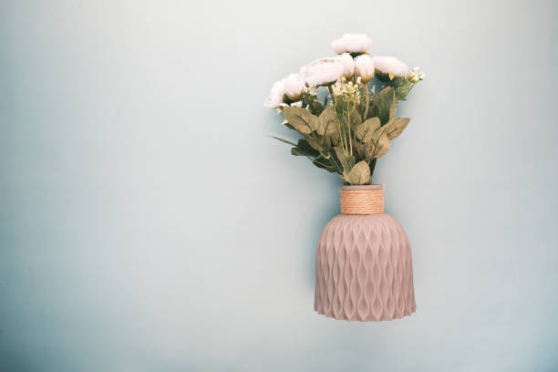 istock hand holding rose flower against white wall 1393916318