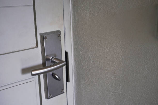 istock Modern door handle with lock mounted on a white door. 1393916402