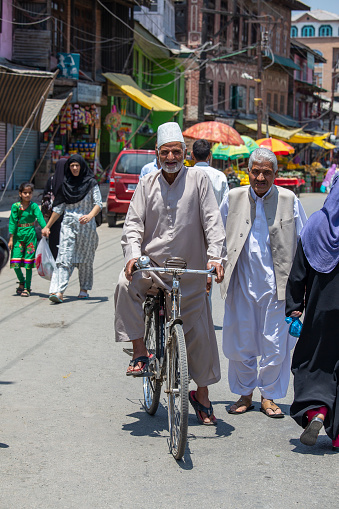 Srinagar, India - july 03, 2015 : Old indian man on bike at street market in Srinagar, Jammu and Kashmir state, India