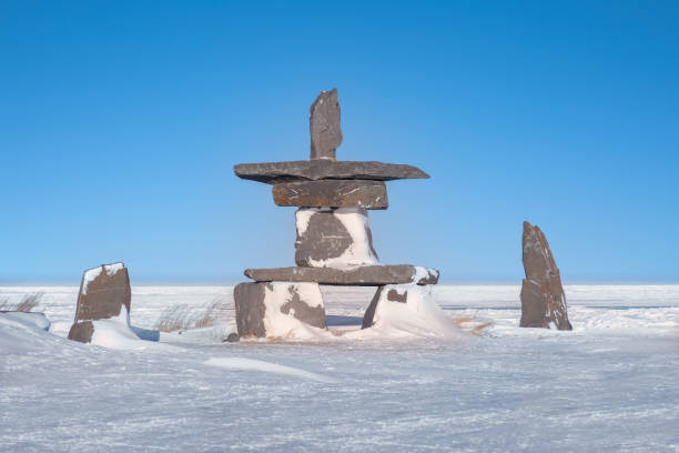 an inukshuk on the frozen shoreline of hudson bay in churchill, manitoba, canada. - arctic canada landscape manitoba imagens e fotografias de stock