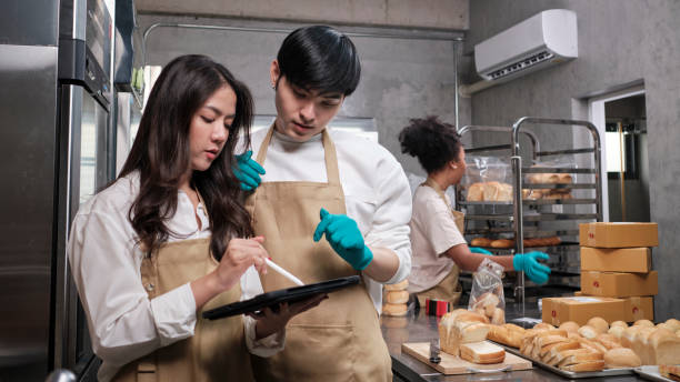Three young startup partners taking online orders, pastry, and bakery food shop. stock photo