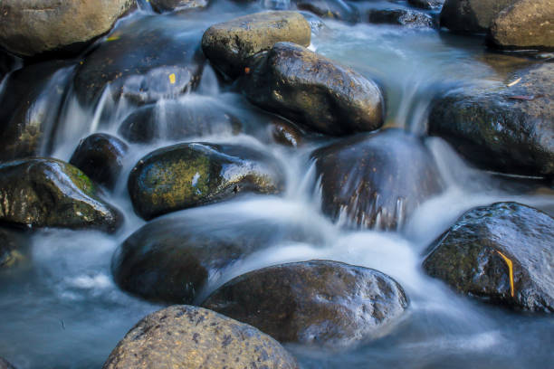 the rocks flow with clear water the water flows between the natural rocks in the river