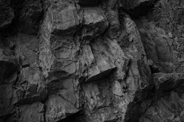 istock Black white rock texture. Rough mountain surface. Close-up. Volumetric stone background with space for design. 1393935648