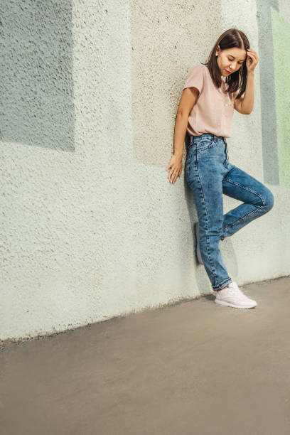 istock Attractive young woman posing against concrete wall. 1393938475