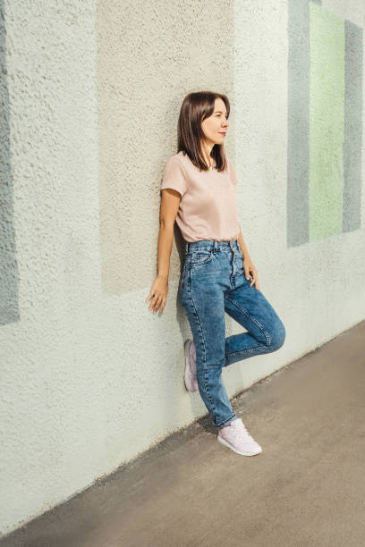 istock Attractive young woman posing against concrete wall. 1393938476