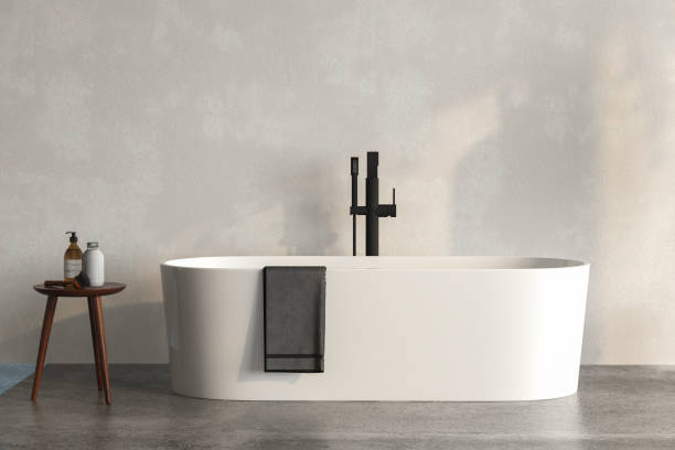 A white bathtub standing on a concrete platform with with wall background. stock photo