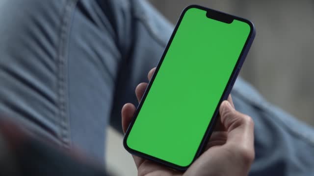 Man Using Smartphone in Vertical Mode with Green Mock-up Screen, 4k