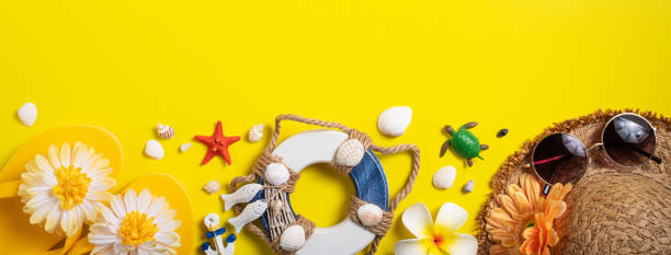 istock Summer beach design concept with shells, hat, slipper on yellow background. 1393945713