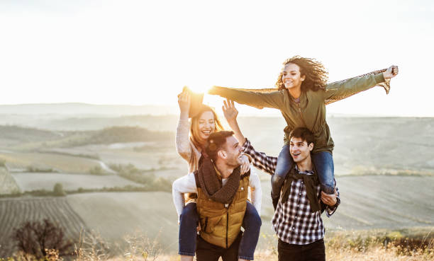 istock Young carefree couples having fun during autumn day on a hill. 1393947205