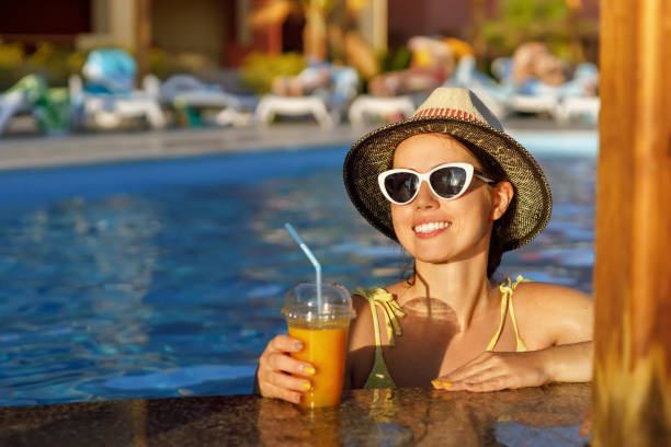 istock smiling woman drinking cocktail in pool bar 1393948253