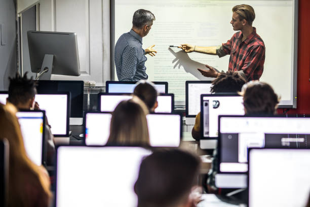istock Male student talking to a professor about the lecture at computer class. 1393948524