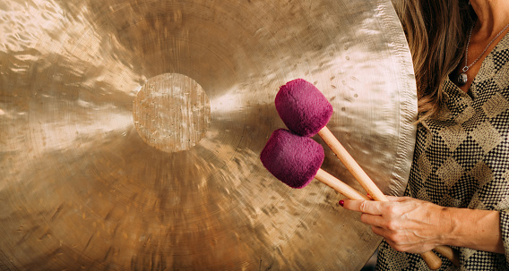 Playing gong in sound bath therapy