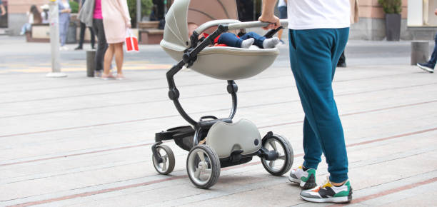 istock Father walking in city baby in stroller. 1393950522