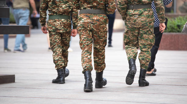 istock Soldiers on uniform walking in the city. 1393950533