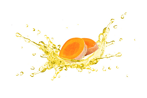 Turmeric (curcumin, Curcuma longa Linn) slice with tumeric essential oil drop dripping isolated on white background.