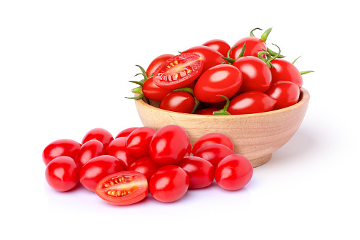 Fresh red cherry tomatoes with half sliced in wooden bowl isolated on white background.