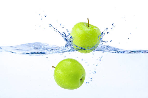 istock green apple falling in blue water splash 1393950841