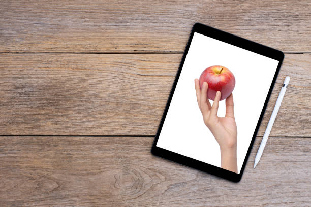 Digital tablet computer with woman hand hold red apple on  screen