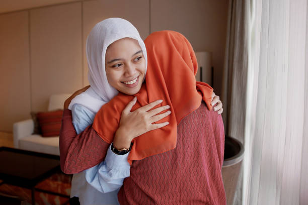 Young Muslim Woman Embracing Family Visit stock photo