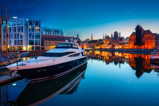 Historic port crane in Gdansk reflected in the Motlawa river at dusk, Poland stock photo