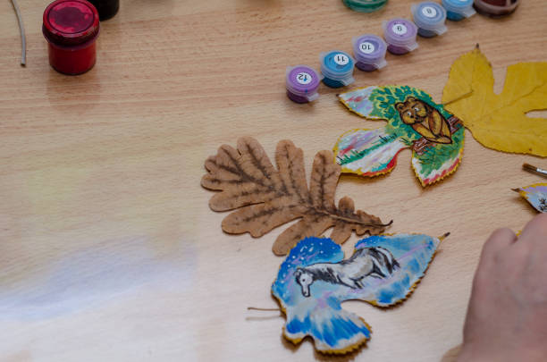 The artist draws on dry fallen leaves.