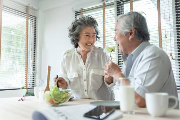 ハッピーシニア大人カップルが一緒に健康的なサラダを食べる - married ストックフォトと画像