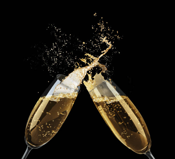 istock Clinking glasses of sparkling wine with splash on black background 1393957670