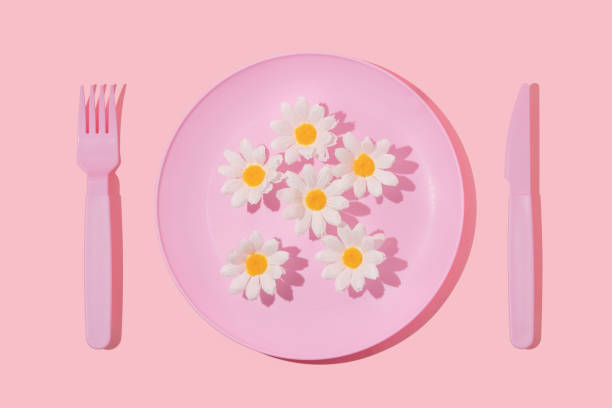istock Spring creative layout with pastel pink plate, fork,knife and white flowers on pastel pink background. 80s or 90s aesthetic fashion food restaurant concept. Minimal summer idea. 1393957958