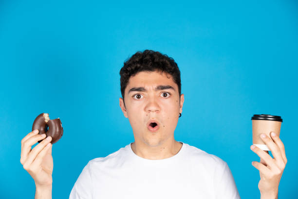 istock Hispanic man holding coffee and donut 1393959213