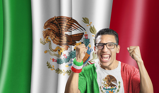 Soccer fan national team of Mexico celebrating goal in front of flag