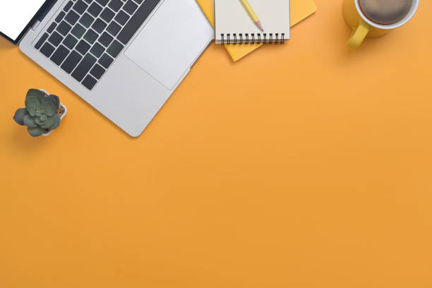 istock Computer laptop, coffee cup, notepad and succulent plant on yellow background with copy space. 1393967097