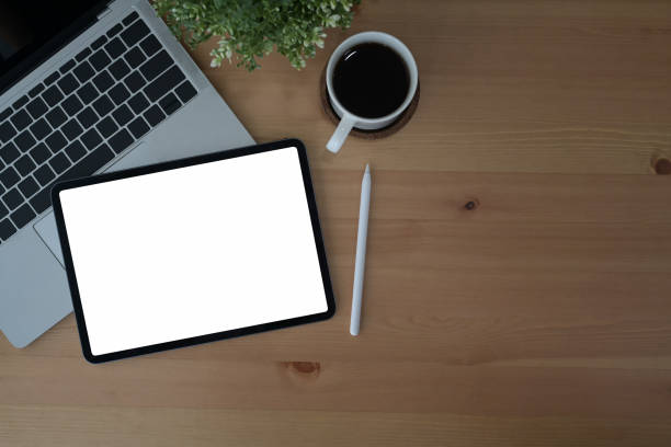 istock Comfortable workplace with digital tablet, laptop computer and coffee cup on wooden background. Top view. 1393968450