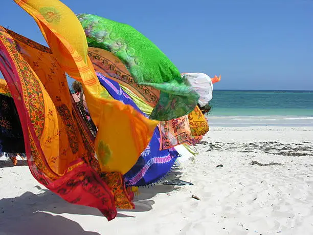 The colorful wares of a cloth merchant blowing on the beach in Mombasa, Kenya