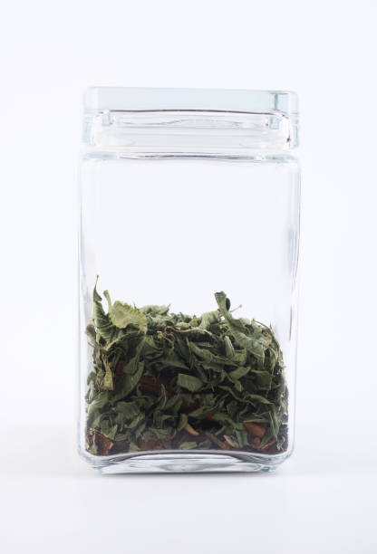 Dry mint in a glass jar isolated on white background.