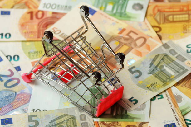 Empty inverted shopping cart on euro money background - Concept of purchasing crisis stock photo