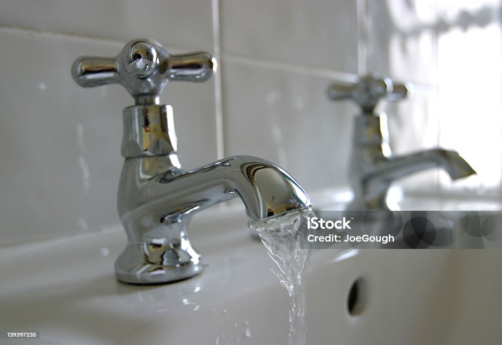 Closeup of a faucet leaking and splashing water into sink Chrome Victorian Faucet/Tap Bathroom Stock Photo