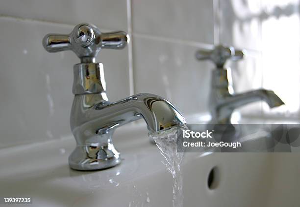 Closeup Of A Faucet Leaking And Splashing Water Into Sink Stock Photo - Download Image Now