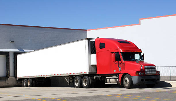 Red truck with trailer attached in parking lot Tractor trailer sitting at a loading dock.  Space for text on the trailer. loading bay stock pictures, royalty-free photos & images