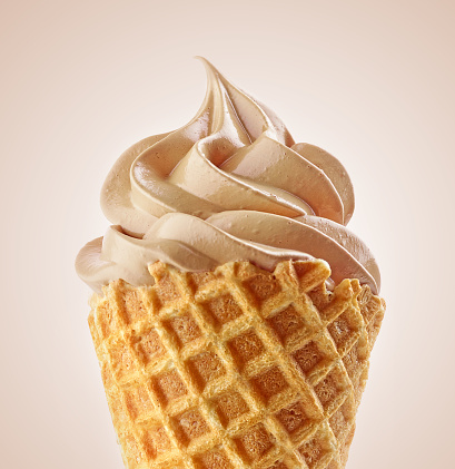 close up of soft ice cream cone isolated on beige background
