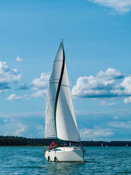 one sailing yacht sailing at full sail on a lake - sea water single object sailboat imagens e fotografias de stock