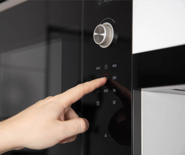 istock A man's hand presses the touch panel of a modern microwave oven to select the power and function of heating food. Close-up 1393976166