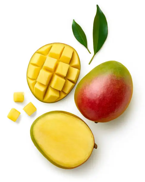 Photo of Fresh whole half and sliced mango fruit and leaves