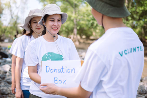 Group of asian diverse people volunteer holding a donation box for fundraiser to emergency situation such as help ukraine, flood victims, food for children, charity event.Volunteering conceptual. grupo de personas asiáticas diversas voluntarias que sostienen una caja de donación para recaudar fondos para situaciones de emergencia, como ayudar a ucrania, víctimas de inundaciones, alimentos para niños, eventos de caridad. voluntariado conceptual.