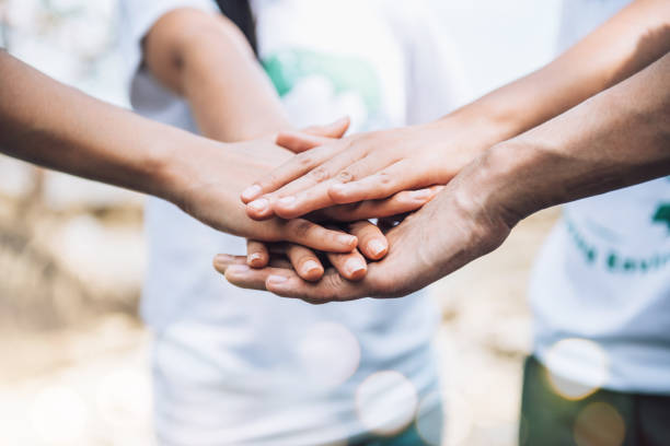 istock Close up of people volunteer teamwork putting hands together,Stack of hands,Unity and teamwork on world environment day. 1393976546