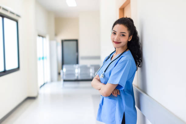 Female doctor stands at hospital. Healthcare worker. woman pharmacist with and stethoscope smiling satisfied with her job in hospital. black health professional wearing stethoscope for support Patient stock photo