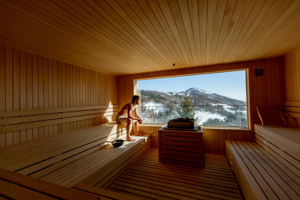 istock Young man relaxing in the sauna and watching winter forest through the window 1393977950
